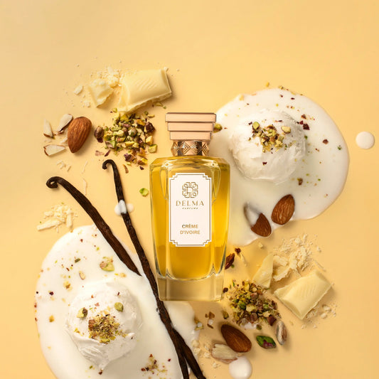 Le flacon Crème d'Ivoire de DELMA Parfums parmi la crème glacée, les pistaches, les amandes, les gousses de vanille et le chocolat blanc