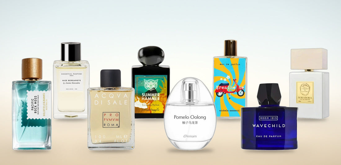 Les huit parfums de niche de la sélection été PlanèteBeauty : Pacific Rock Moss, Nice Bergamote, Acqua di Sale, Summer Hammer, Pomelo Oolong, Breathe Me, Wavechild et Borabora, posés sur une lumière de bord de mer.