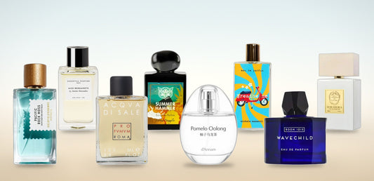 Les huit parfums de niche de la sélection été PlanèteBeauty : Pacific Rock Moss, Nice Bergamote, Acqua di Sale, Summer Hammer, Pomelo Oolong, Breathe Me, Wavechild et Borabora, posés sur une lumière de bord de mer.
