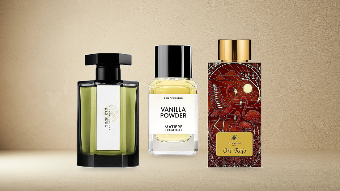 Trois flacons réels du catalogue, une appellation chacun : Timbuktu de L'Artisan Parfumeur en eau de toilette, Vanilla Powder de Matière Première en eau de parfum, Oro Rojo d'AB Signature Paris en extrait, sur un fond de plâtre ivoire.