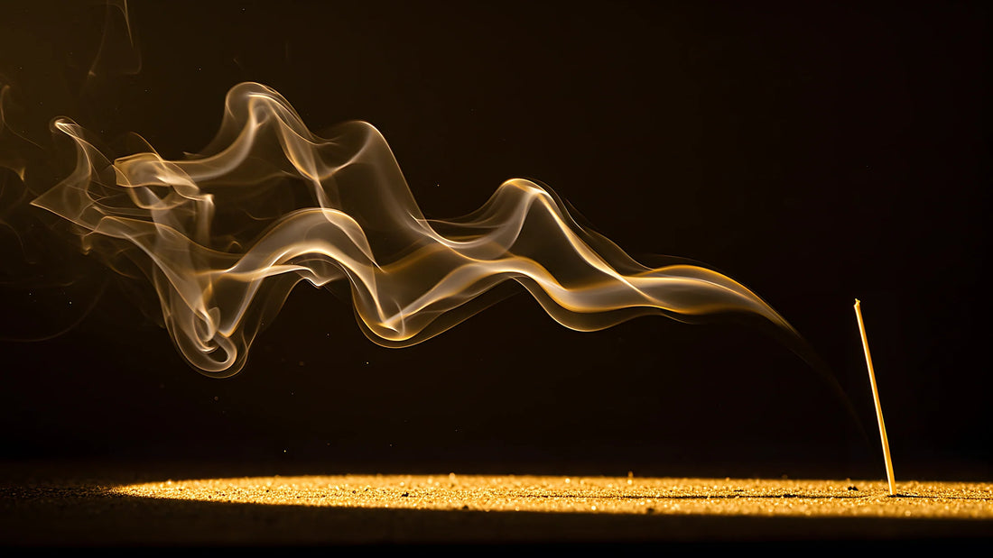 Volute de fumée dorée traversant l'obscurité au-dessus d'un sol de sable clair, image d'illustration pour un article sur le sillage d'un parfum.