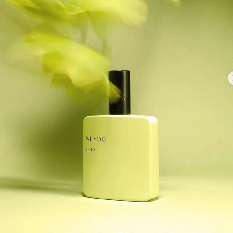 Un flacon de parfum de couleur sarcelle enfermé dans de la glace.