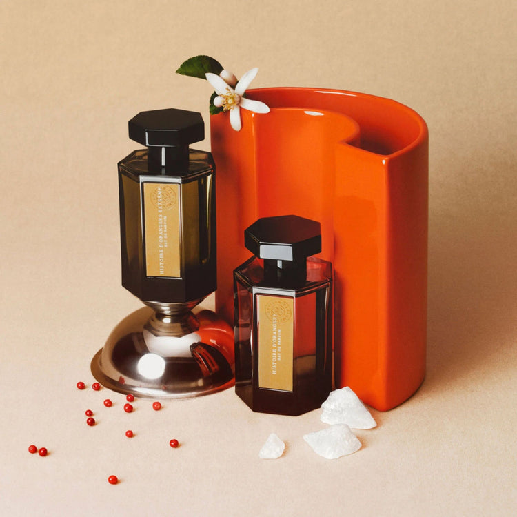 Un flacon de parfum en verre foncé avec un bouchon noir et une étiquette blanche.