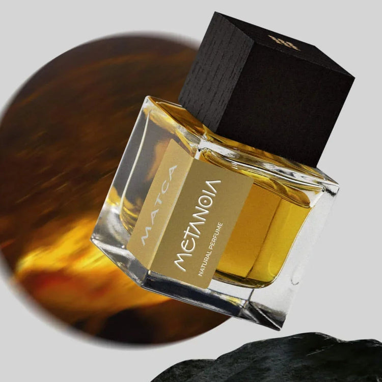 Un flacon de parfum de couleur dorée avec un bouchon noir.