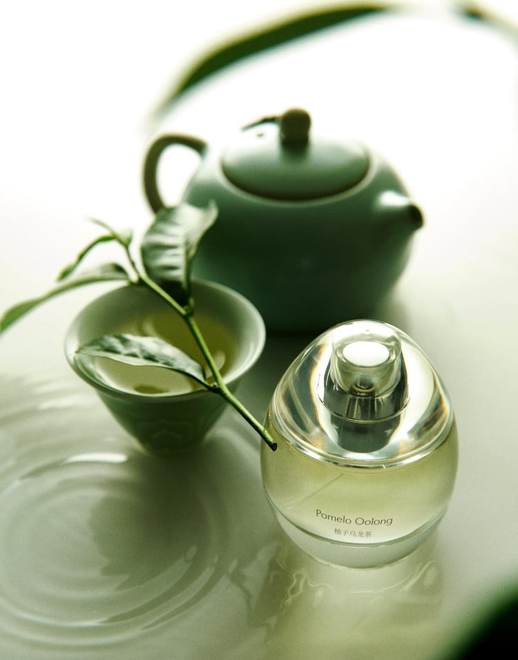 Un élégant flacon de parfum en verre transparent avec un liquide légèrement ambré et un bouchon transparent assorti.