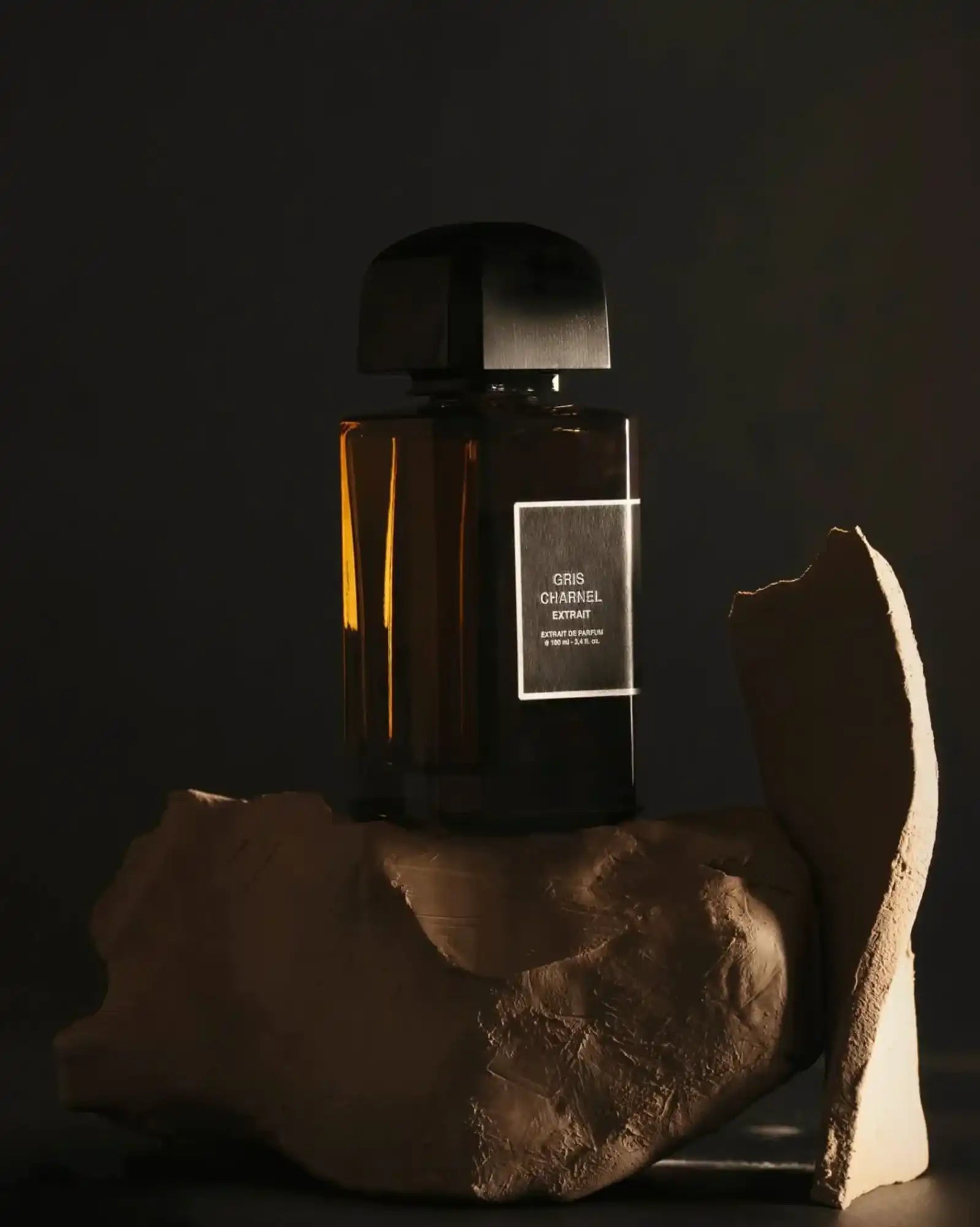 Bouteille en verre ambré avec bouchon noir, design minimaliste.