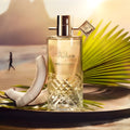 By Kilian Piña Paraíso Eau de Parfum 75ml — flacon sur plage au soleil couchant, palme et noix de coco, gourmand tropical niche France