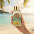 Karès Blan AB Signature Paris — main féminine élégante tenant flacon ivoire plage Anse Source d'Argent Seychelles golden hour